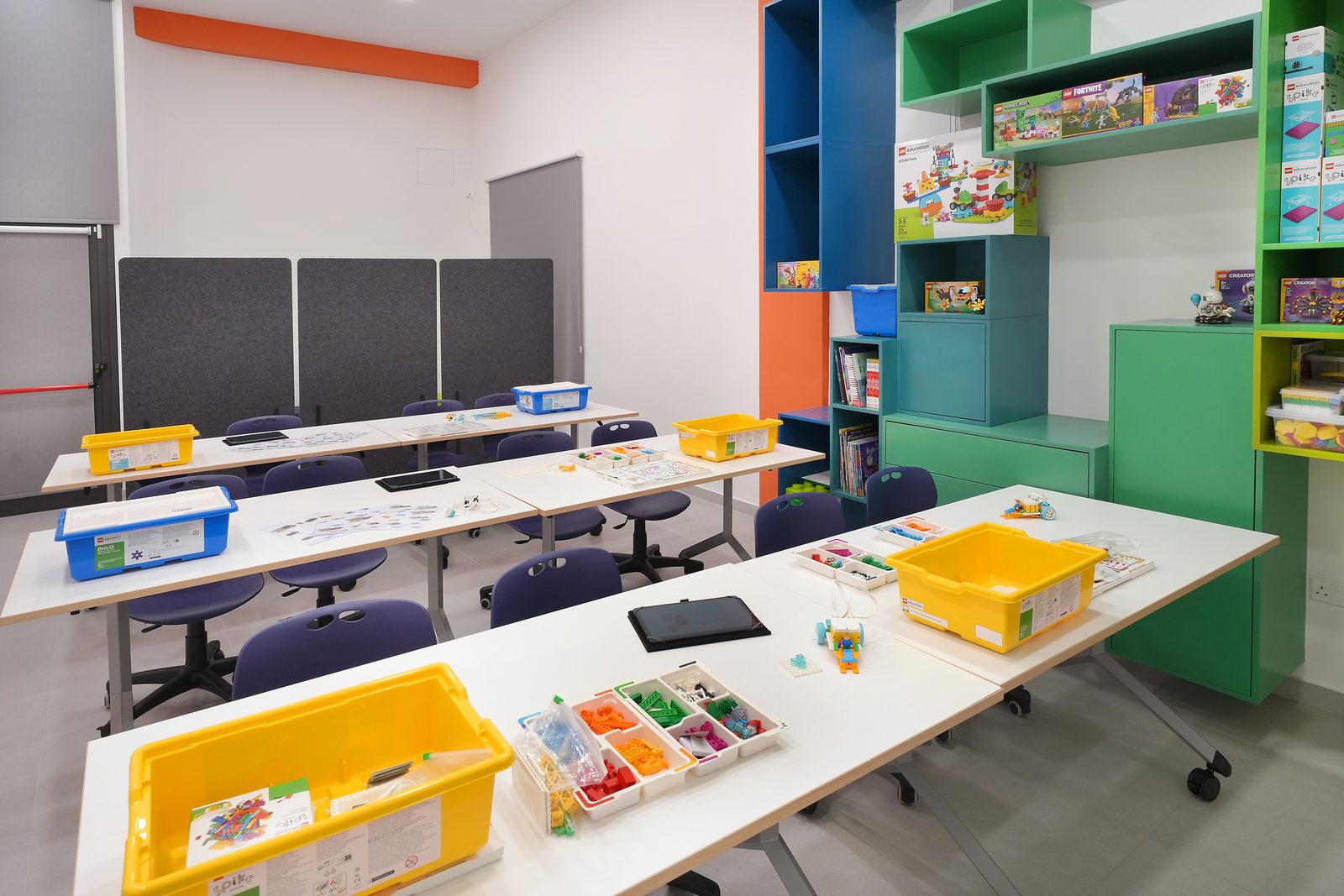 Classroom tables with LEGO Education boxes and tablets ready for a lesson