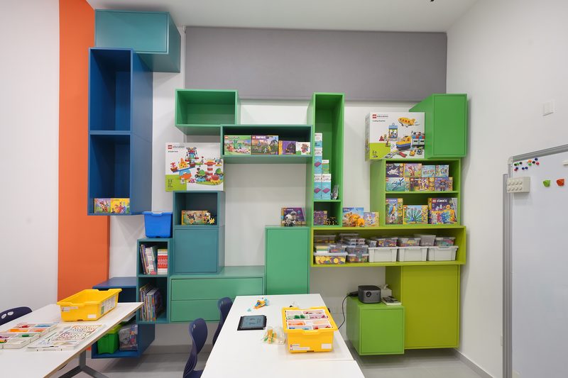 Green and blue shelves stocked with LEGO Education sets